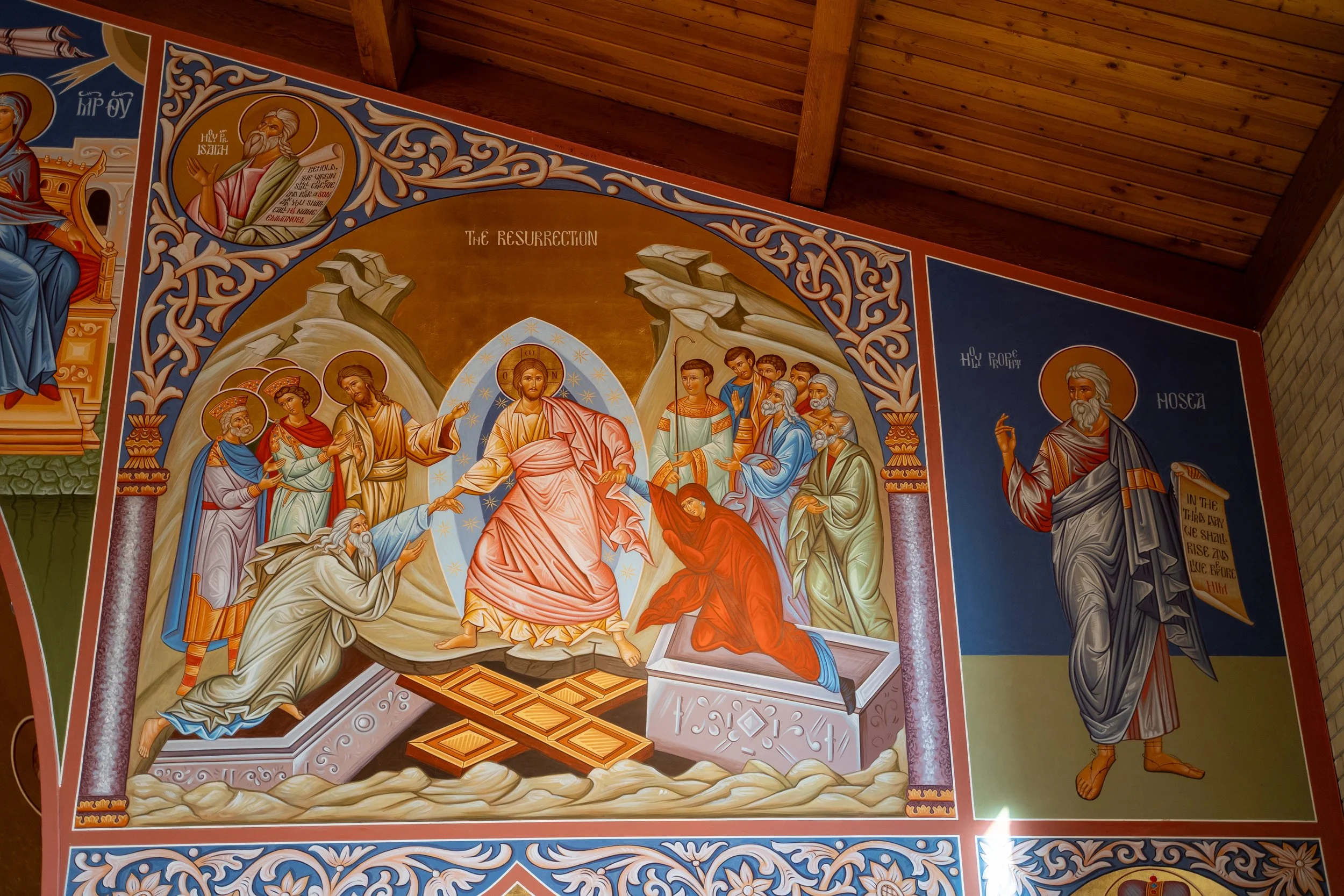 Religious Christian icon mural depicting the resurrection of Jesus Christ, with biblical figures surrounding him and decorative framing, on a church ceiling.