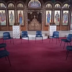 Saint George Orthodox Cathedral class with six empty chairs arranged in a semicircle in front of an ornate iconostasis with religious icons and a central door.