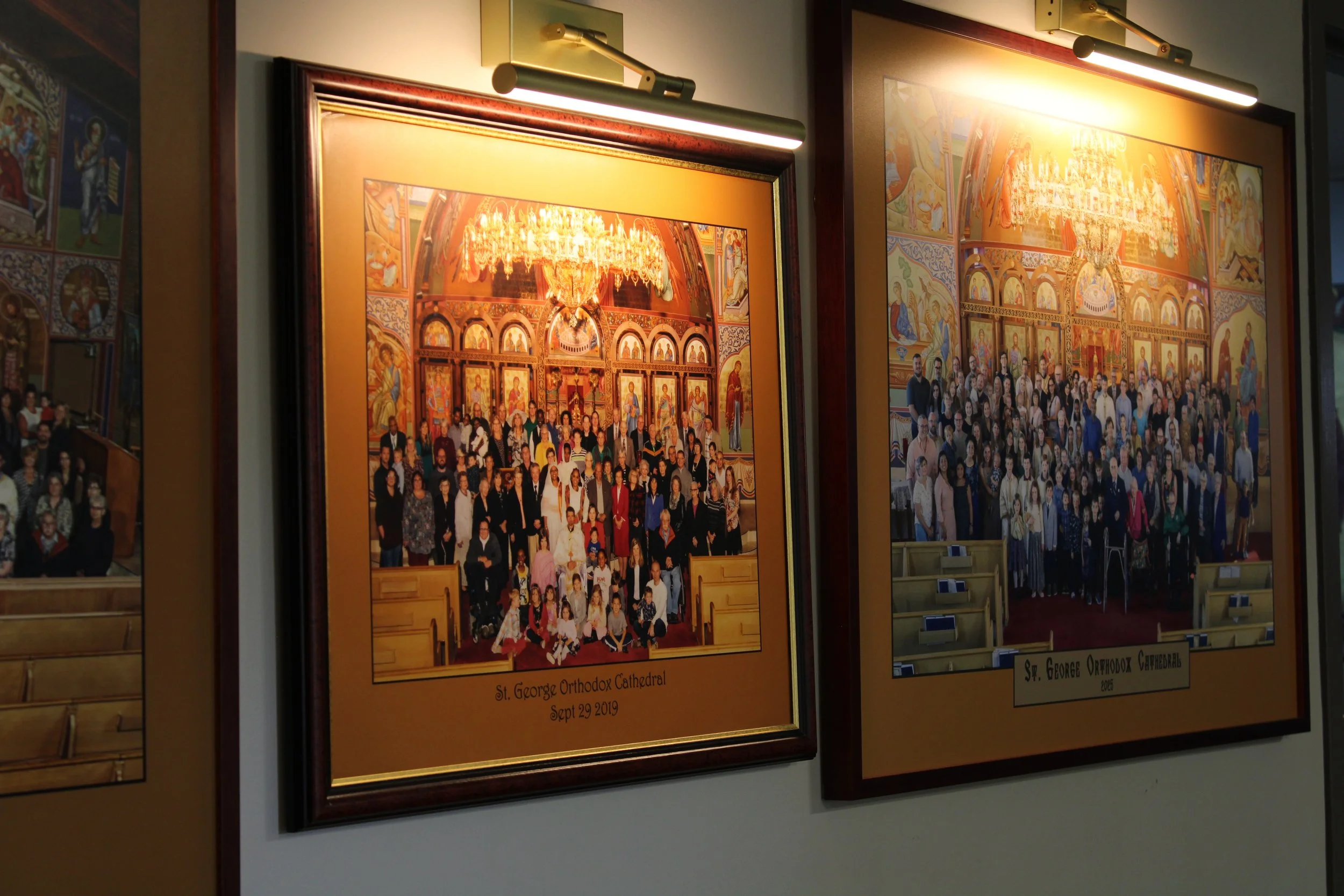 Two framed photographs of a large group of people inside a church, with elaborate religious artwork and a chandelier, likely from a church event. The left frame is labeled 'St. George Orthodox Cathedral Sept 29 2019' and the right one is labeled 'St.