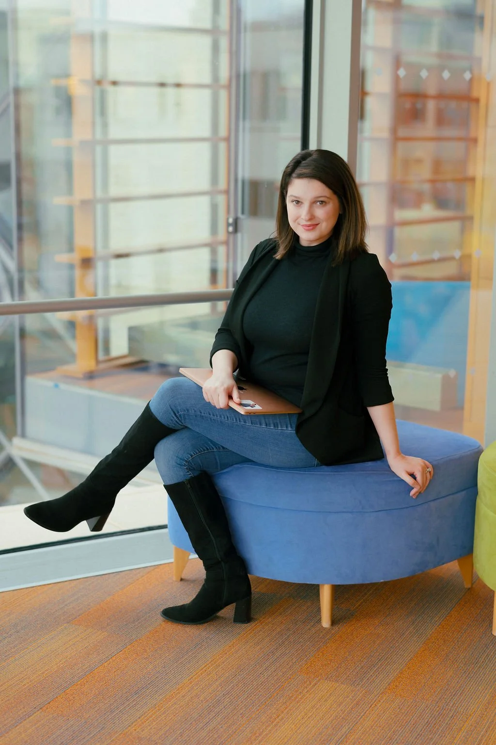 colored photo of author sitting down with their laptop