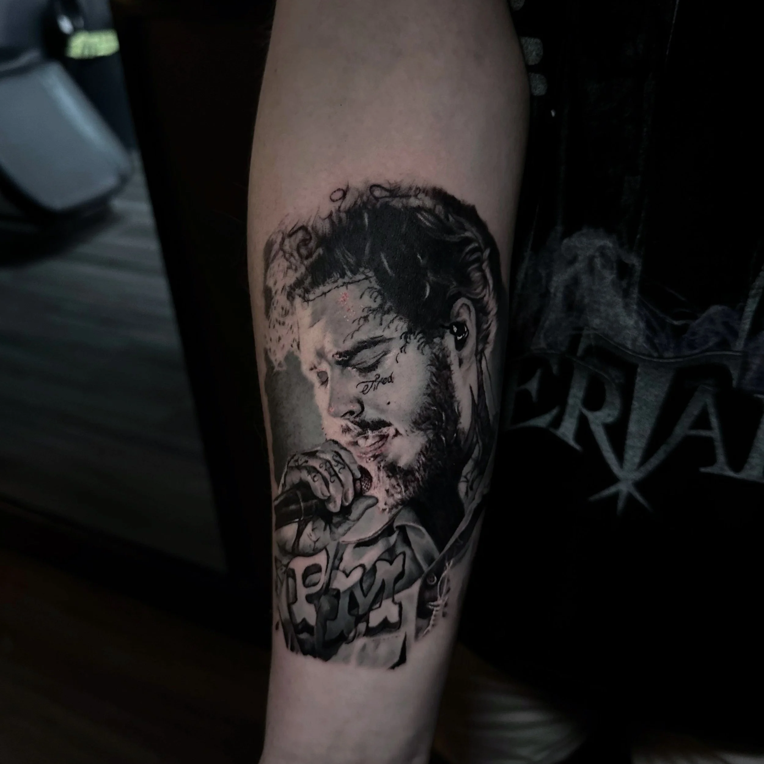 Tattoo of a man singing into a microphone, with detailed shading and realistic features.