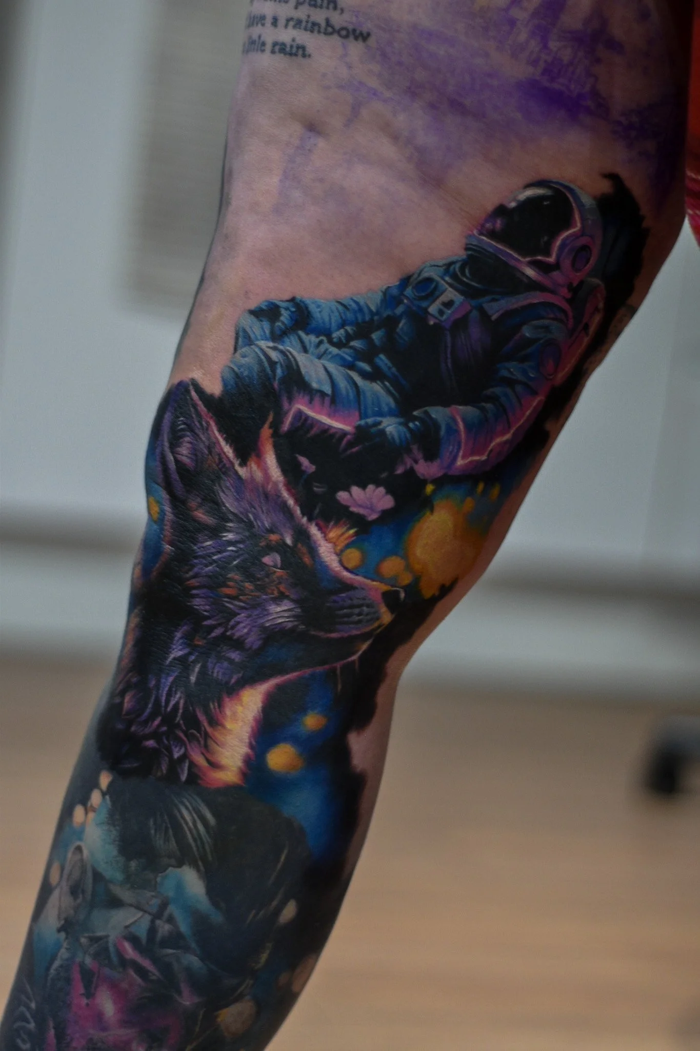 Tattoo of an astronaut and a black cat on a person's arm.