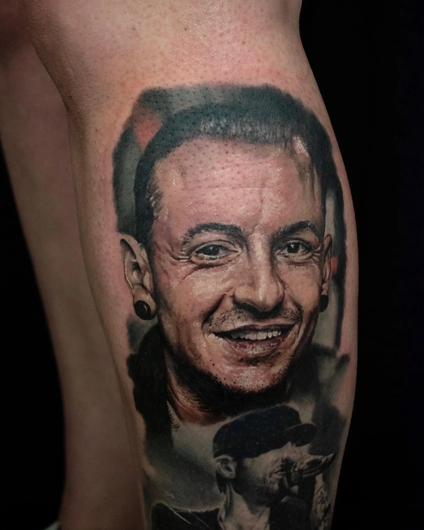 Tattoo of a smiling woman's face with a cap, earrings, and visible wrinkles, on a person's upper arm.