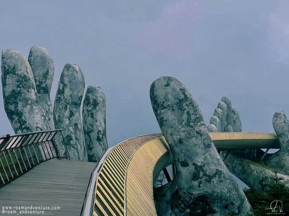 A walkway in the shape of a giant hand forming a finger, part of a larger structure resembling a hand with extended fingers.