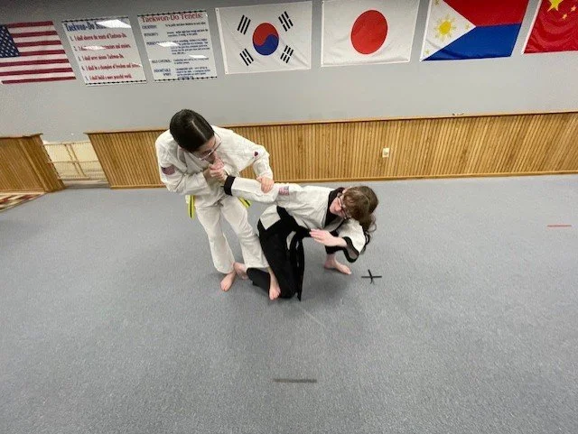 Sparring interaction of two students.  Black belt has been taken down!