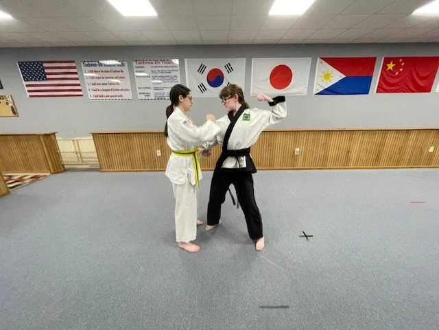Sparring interaction of two students.  Black belt is demonstrating attack. 
