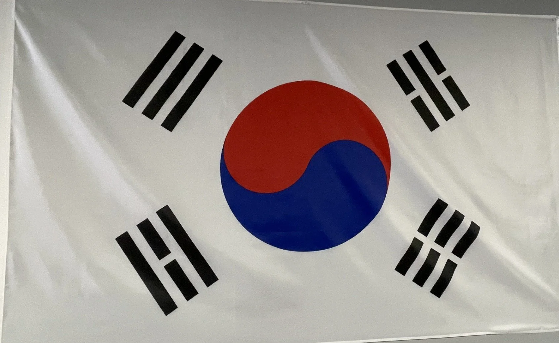 South Korean flag with white background, black trigrams, a red and blue Taegeuk symbol in the center.Picture taken in Shawano Wisconsin, in Central Wisconsin Black Belt Academy
