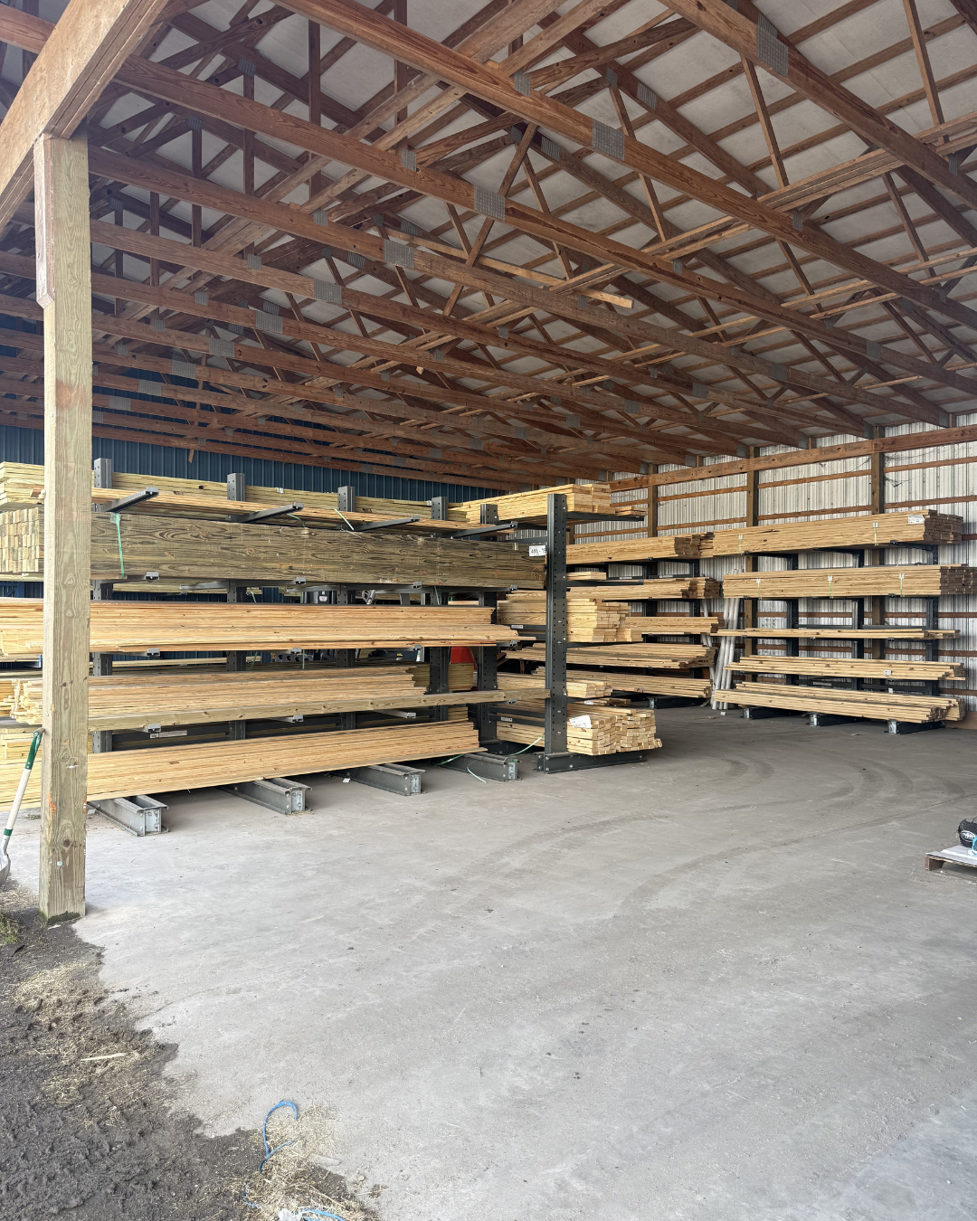 Wooden planks neatly stacked on metal shelving inside a warehouse.