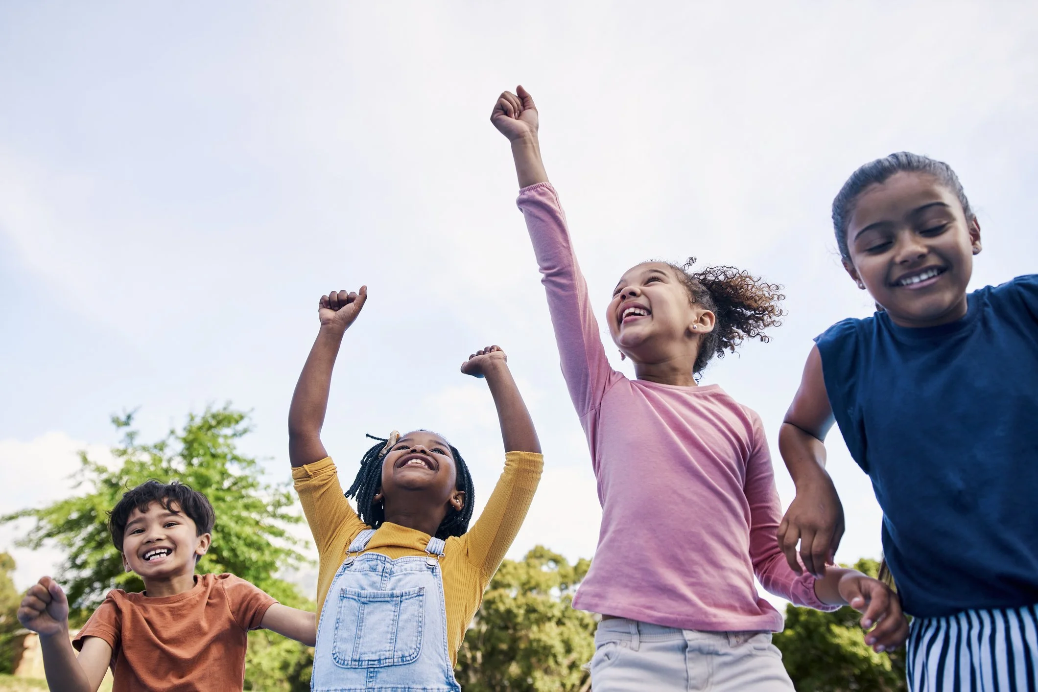 Children jumping and celebrating outdoors at a Comet Drama holiday camp for kids in South London