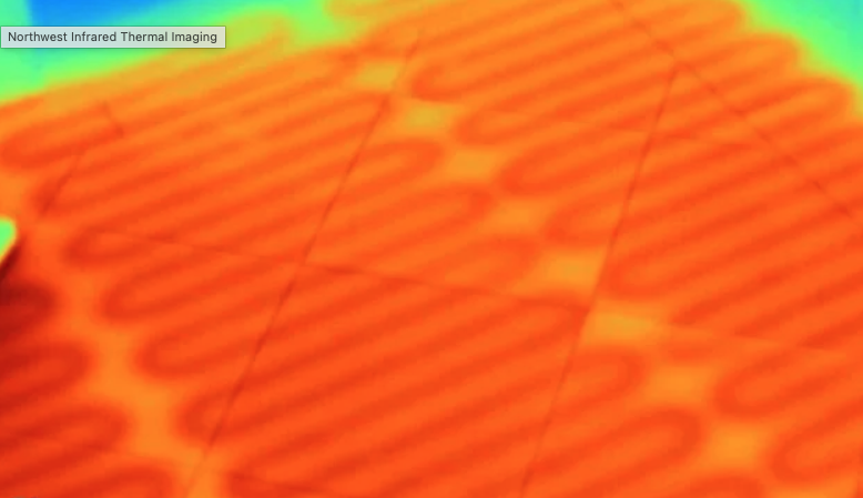 Infrared thermal image showing a grid-like pattern with warm temperature variation in orange and yellow shades.
