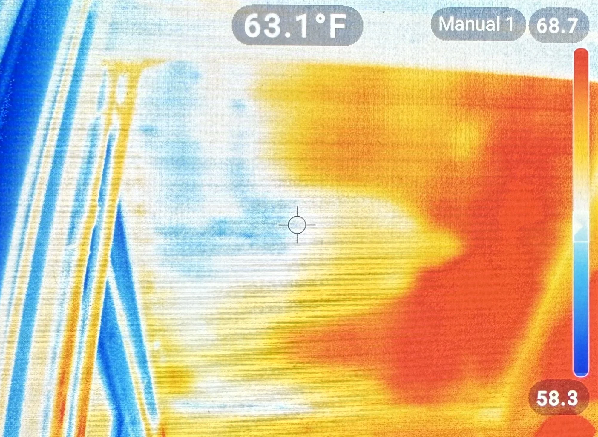 Thermal image of a surface with a temperature of 63.1°F, showing areas in blue, yellow, and red indicating different temperatures, with a vertical temperature scale on the right.