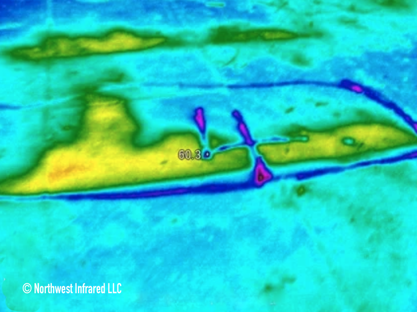 Infrared thermal image of a boat on water with visible temperature readings.