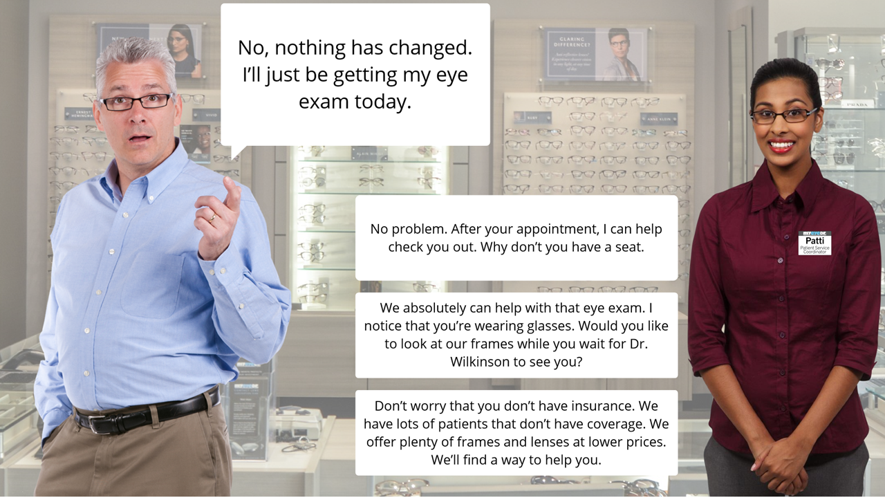 An older man talking to a young female optician in an eyewear store, with multiple eyeglasses displayed on the wall behind them. The man is wearing a light blue shirt and glasses. The female staff member is wearing a burgundy shirt with a name badge that reads "Patti." The man appears to be explaining that he is there for a routine eye exam.