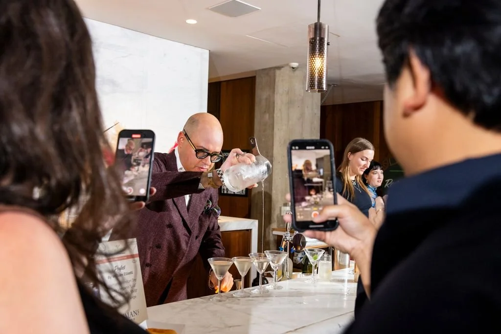 Guests documenting William Elliott pouring cocktails at Martini Expo.