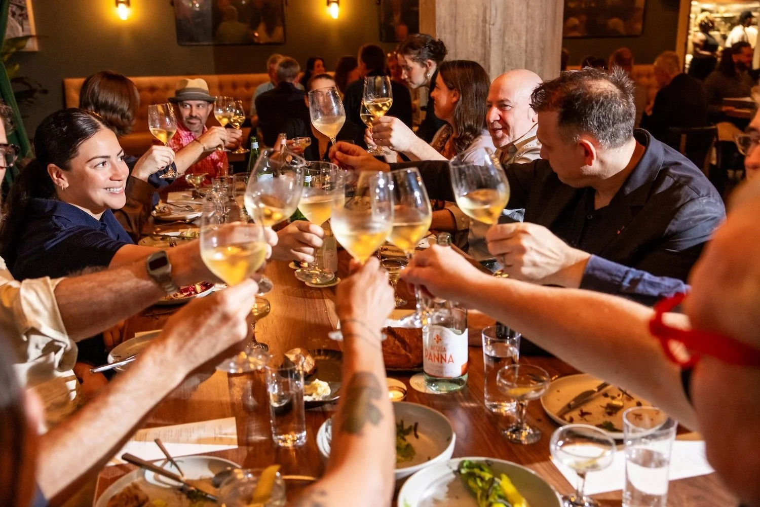 Group of attendees toasting their glasses at Martini Expo dinner.