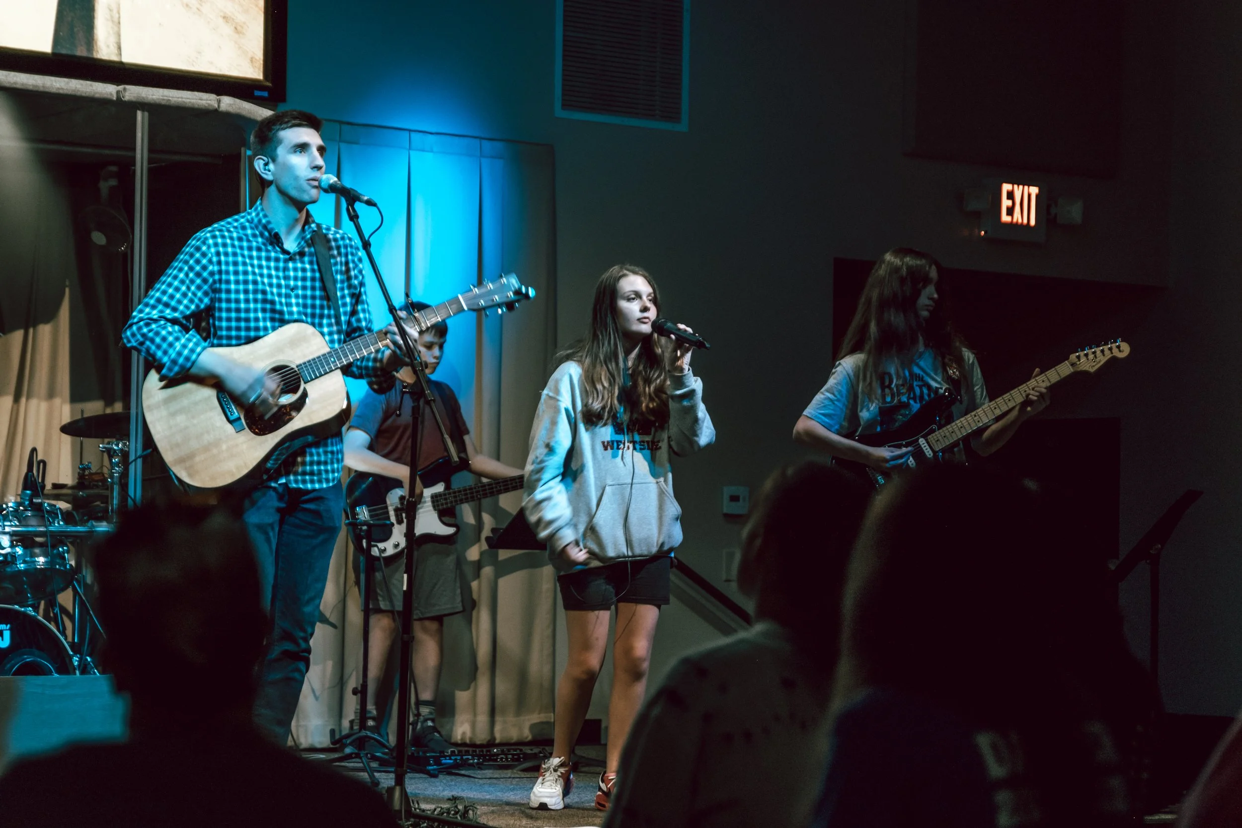 Young band performing live on stage at a venue.