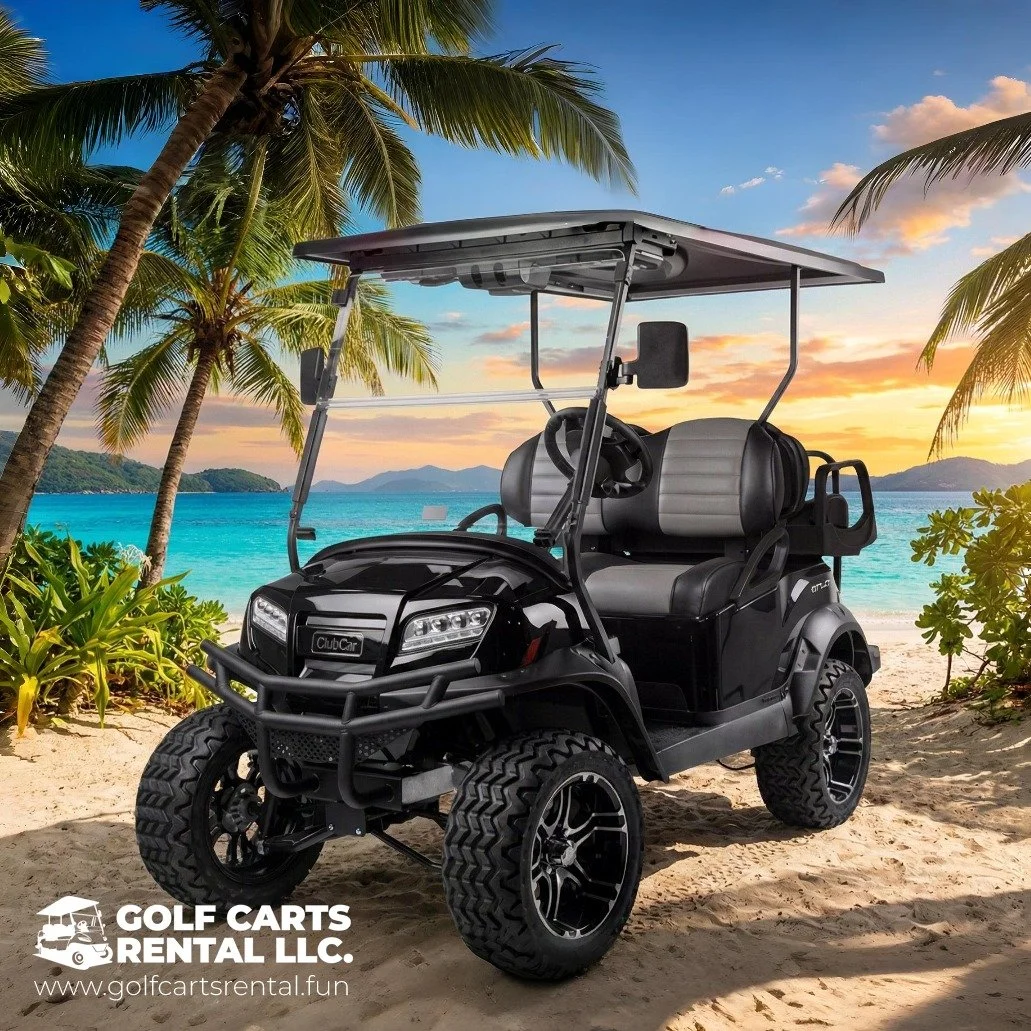 A black golf cart parked on sandy beach with palm trees, ocean, and sunset in the background.