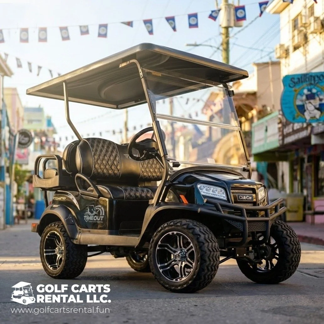 Black golf cart with diamond-patterned seats and large tires parked on a street, decorated with flags overhead, with storefronts in the background.
