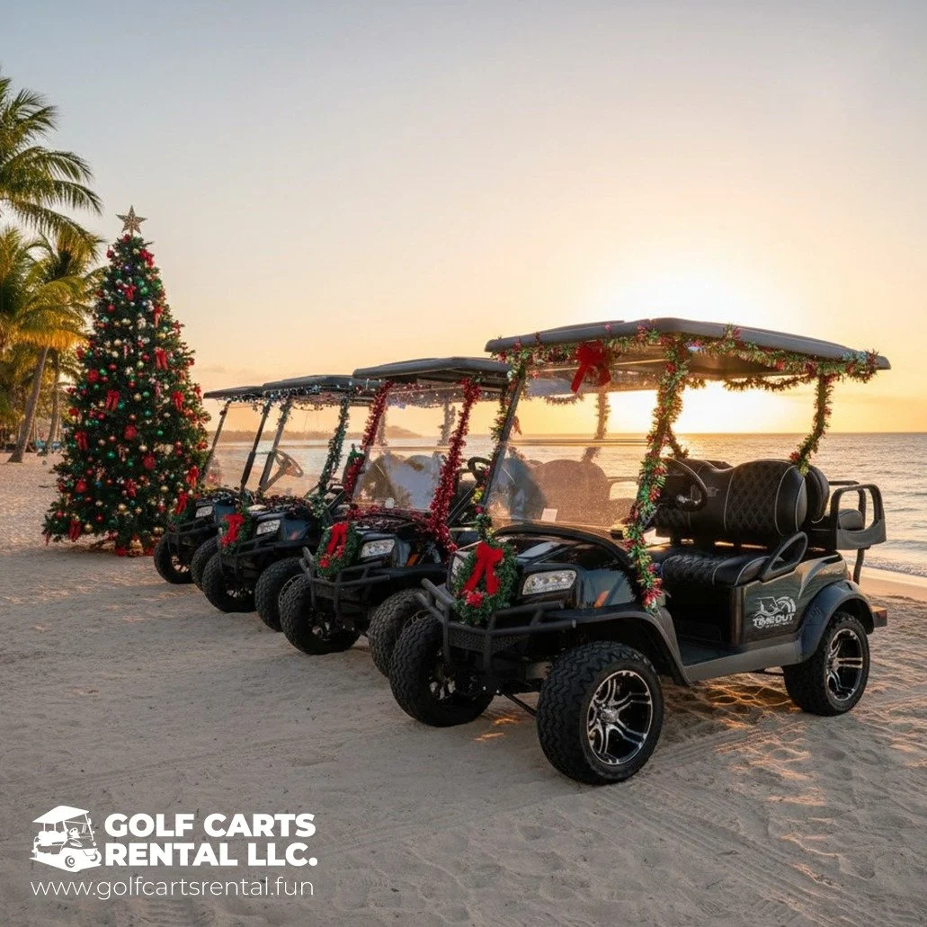 Four decorated golf carts lined up on a beach at sunset with a Christmas tree, palm trees, and holiday decorations in the background.