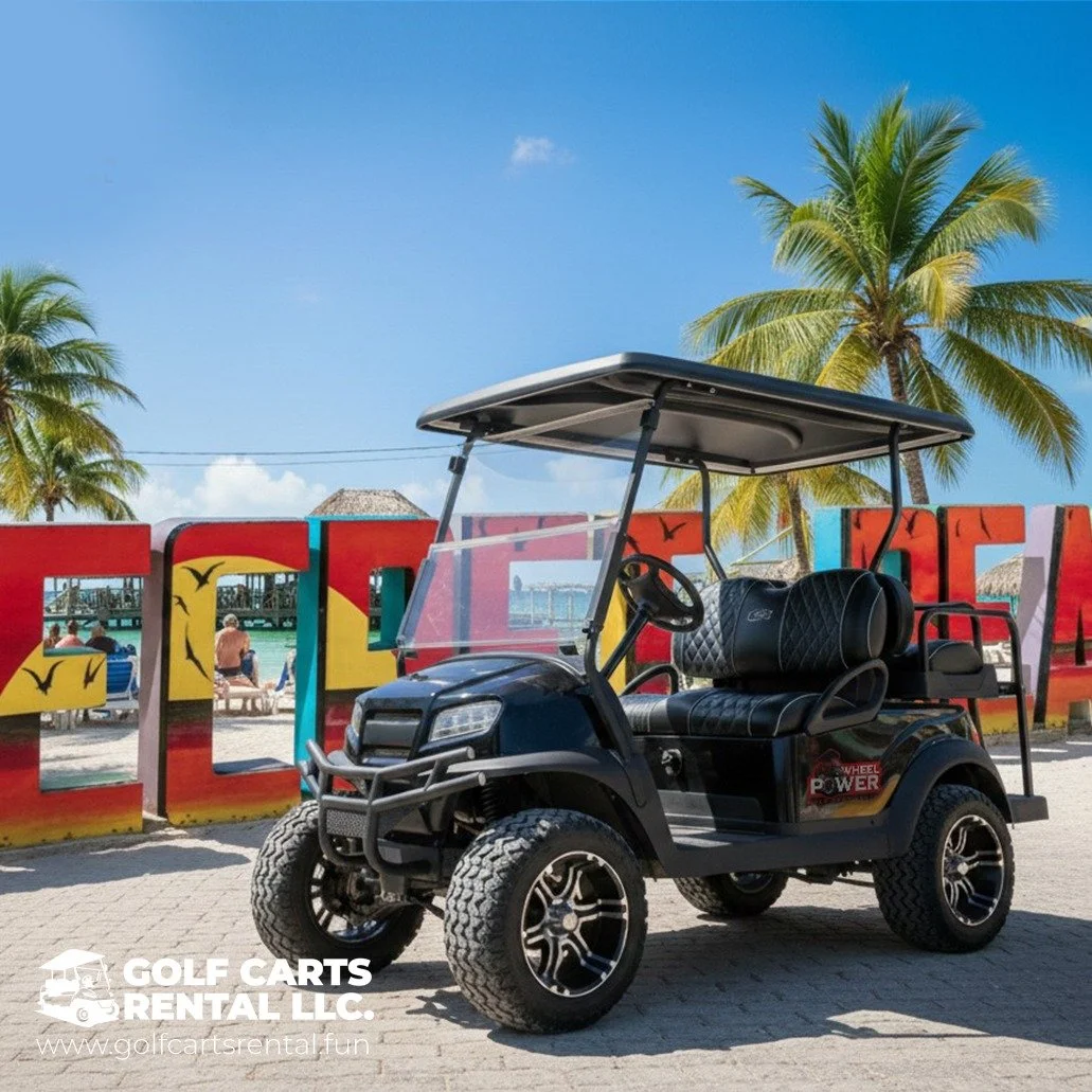 A black golf cart with a roof and two seats parked on a paved area in front of colorful large letters spelling 'CANCUN' with palm trees and a beach scene in the background.