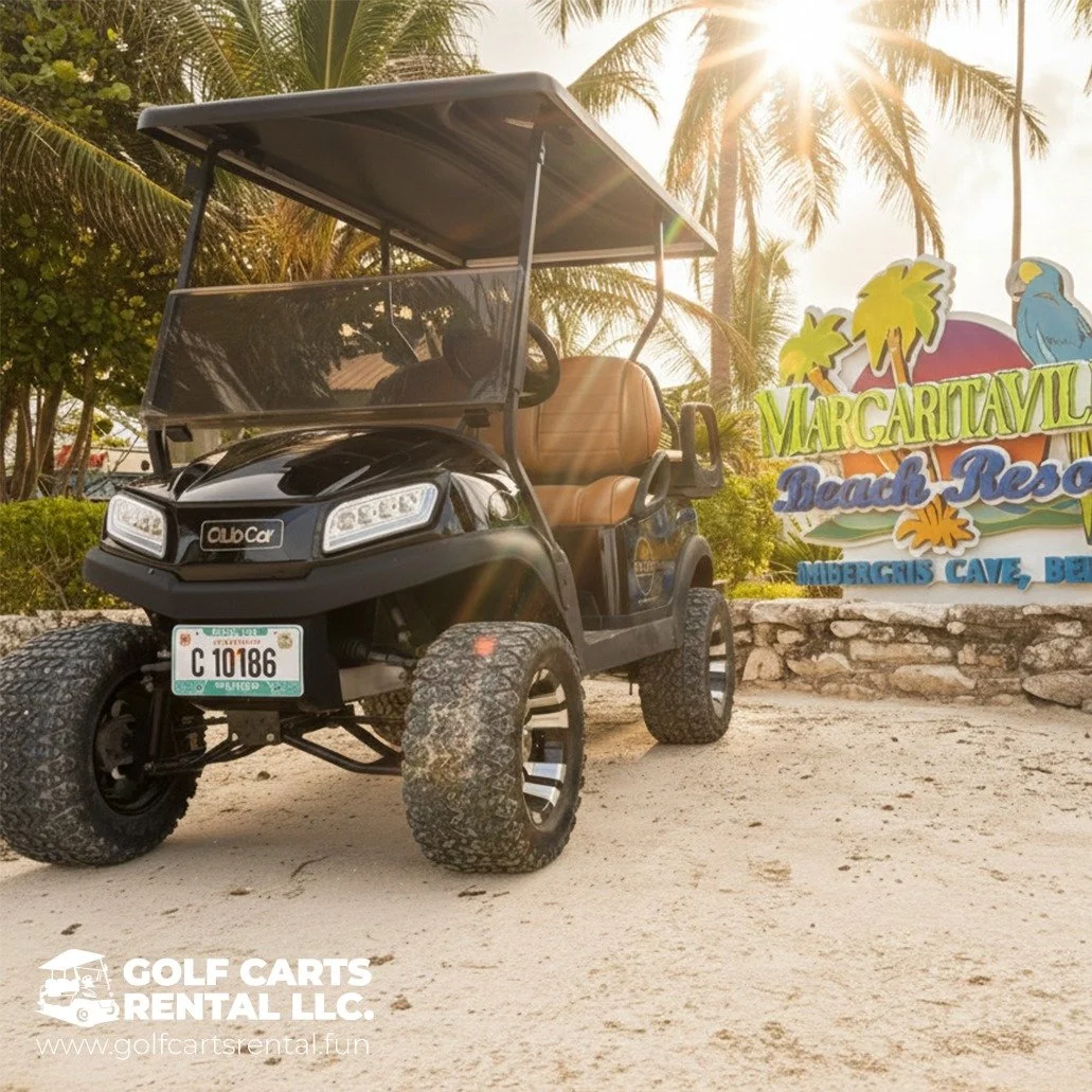 Black golf cart with tan seats parked on sandy ground near palm trees and a colorful sign reading 'Margaritaville Beach Resort' with a parrot graphic, advertising an undersea cave tour or beach resort.