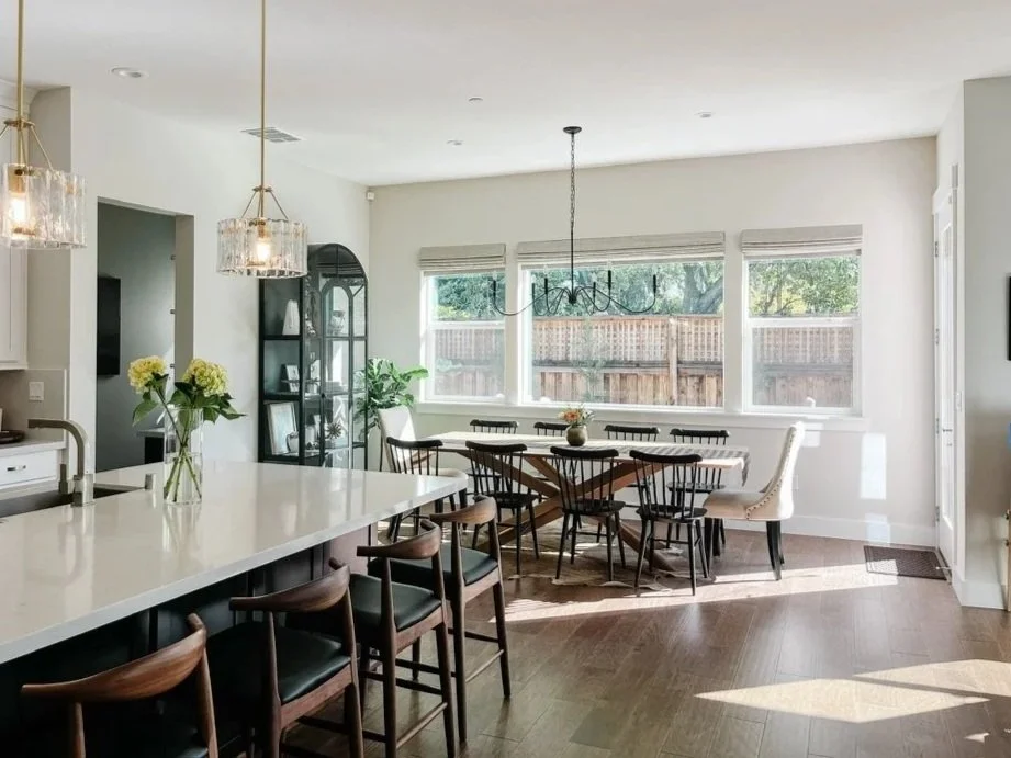 White modern open concept kitchen and dining room with brass accents, oak and walnut furniture, glass pendants--Casa Limones interior design