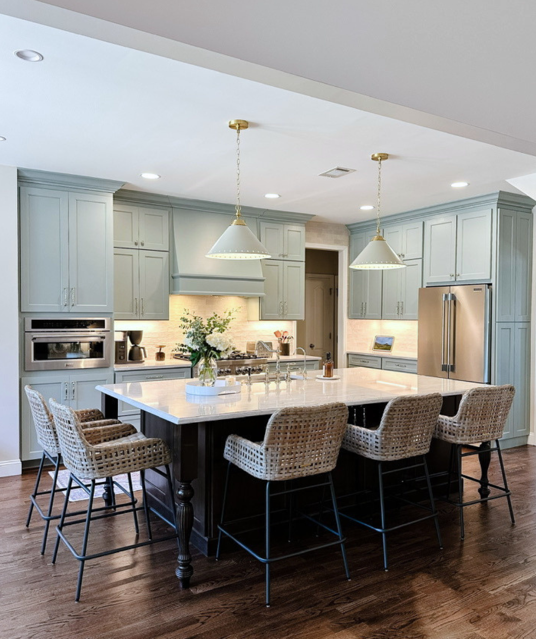 Light blue kitchen with white quartz countertops, walnut island, brass accents, polished nickel hardware, wicker counterstools and vintage runner--Casa Limones interior design