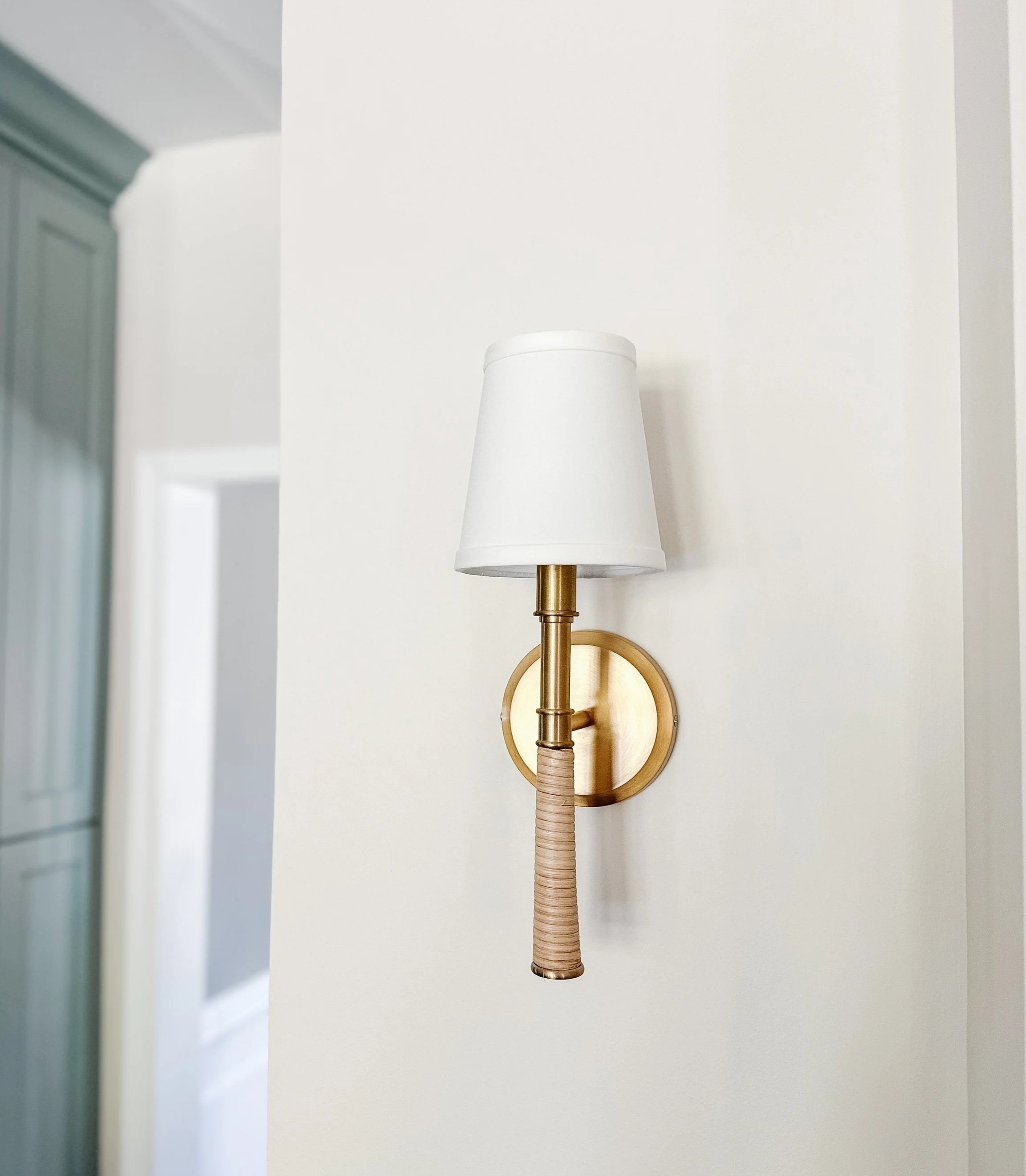 Light blue kitchen cabinets with white and brass sconce--Casa Limones interior design