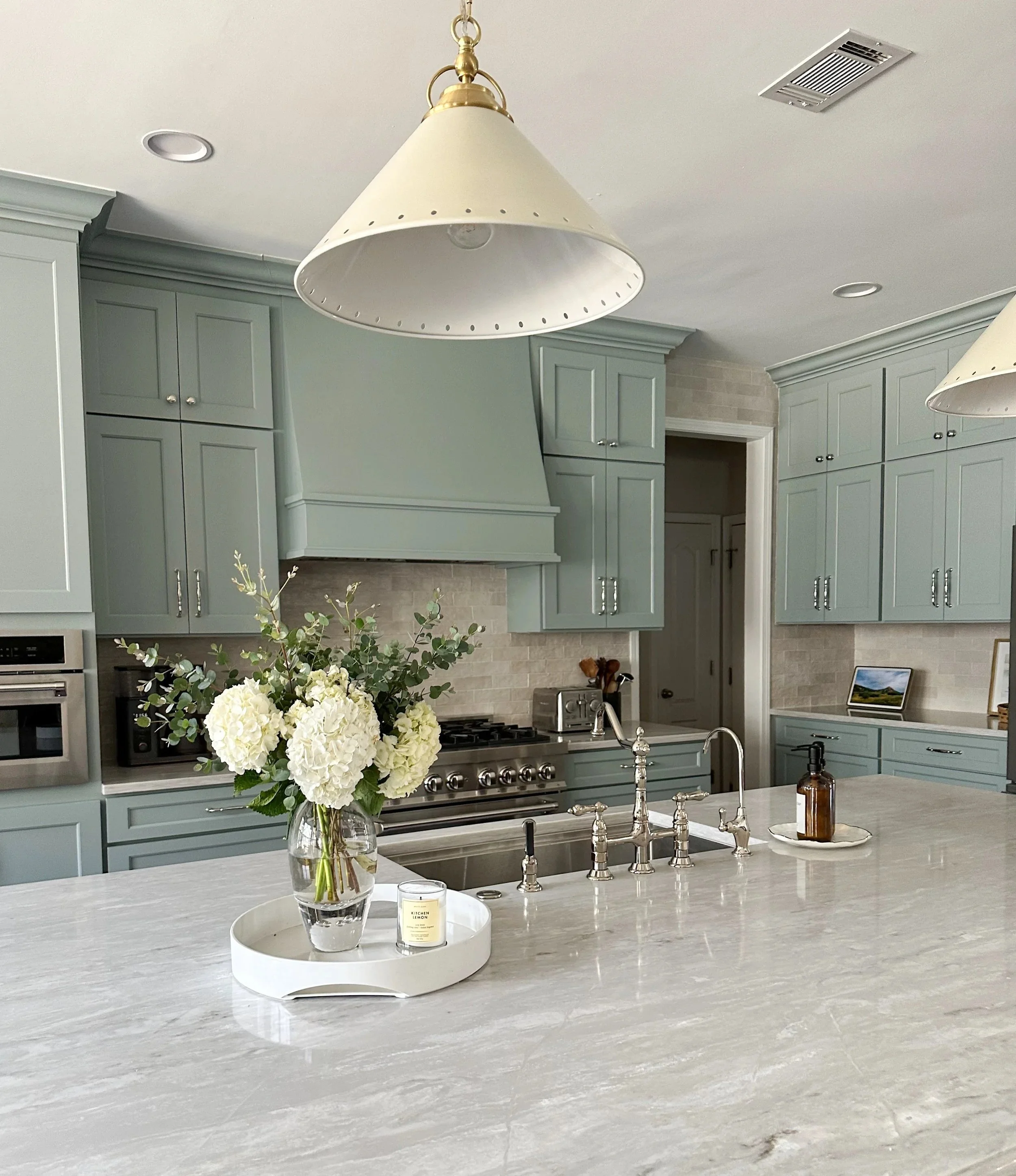 Light blue kitchen with white quartz countertops, polished nickel hardware, and vintage runner--Casa Limones interior design