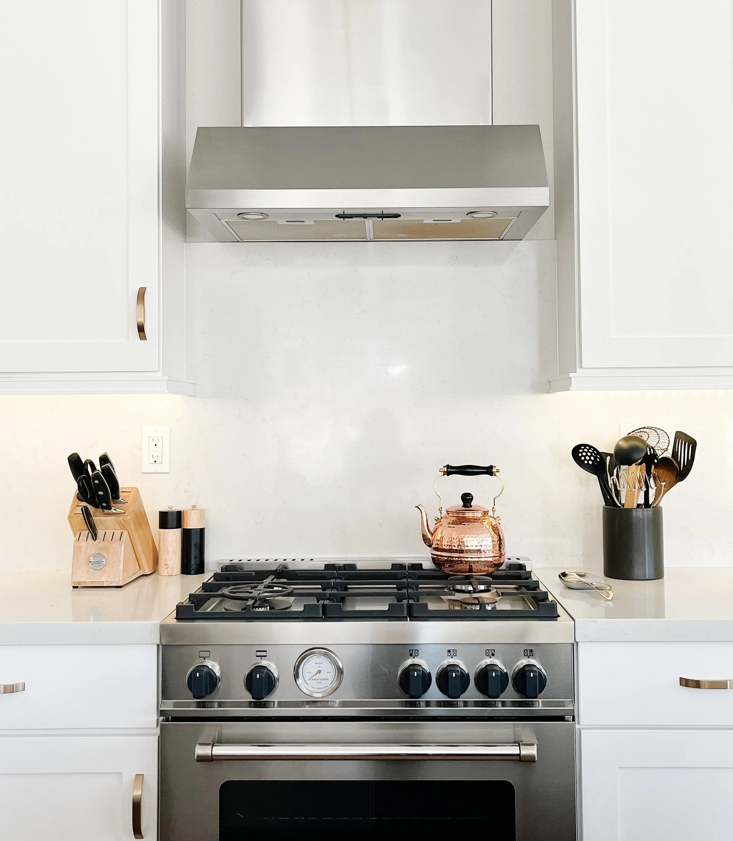 White kitchen with brass hardware, Bertazzoni stove, copper kettle--Casa Limones interior design