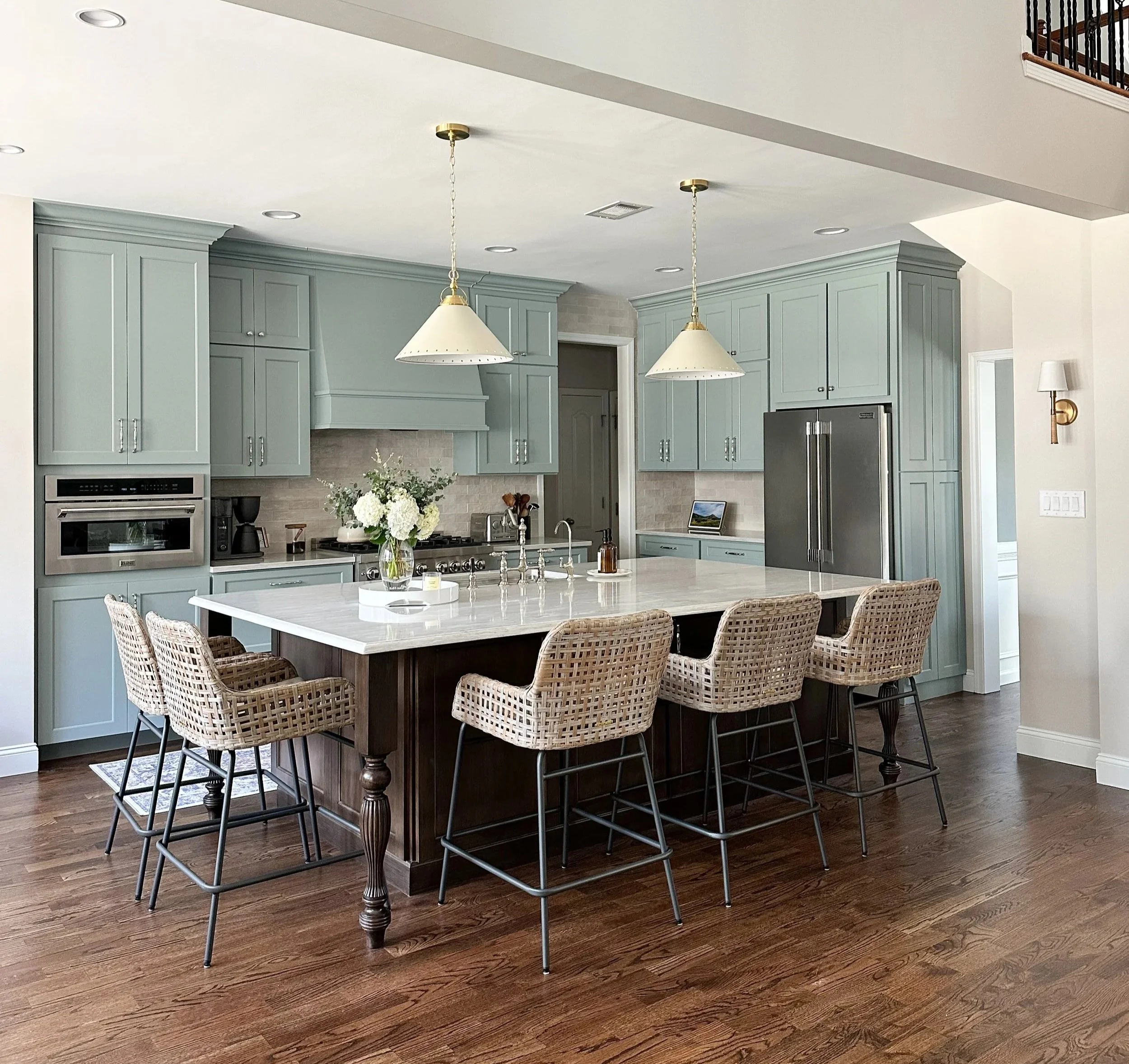 Light blue kitchen with white quartz countertops, walnut island, brass accents, polished nickel hardware, wicker counterstools and vintage runner--Casa Limones interior design