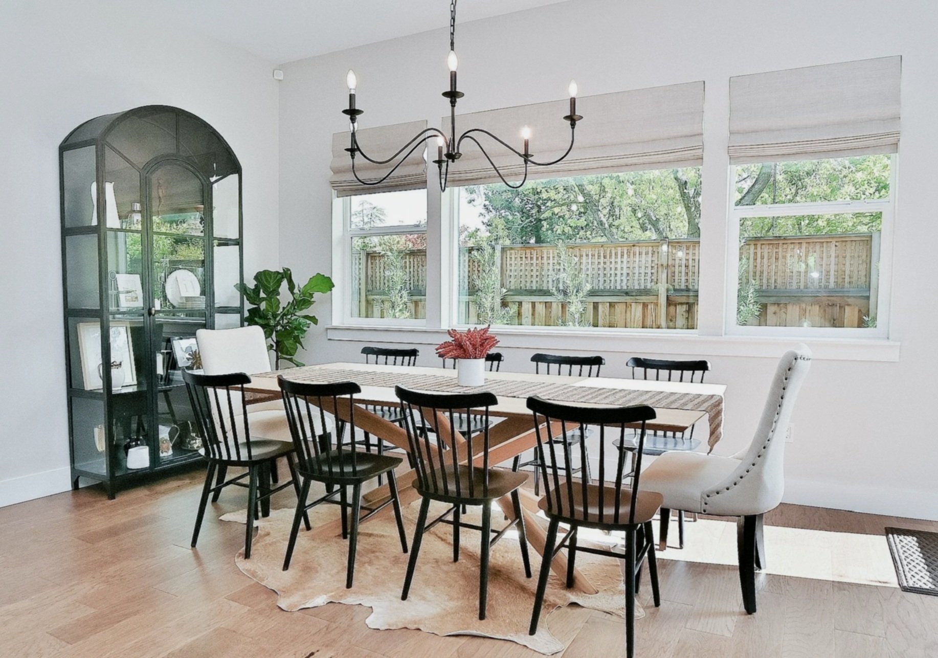Neutral dining room with black accents, hide rug, oak furniture, natural light--Casa Limones interior design