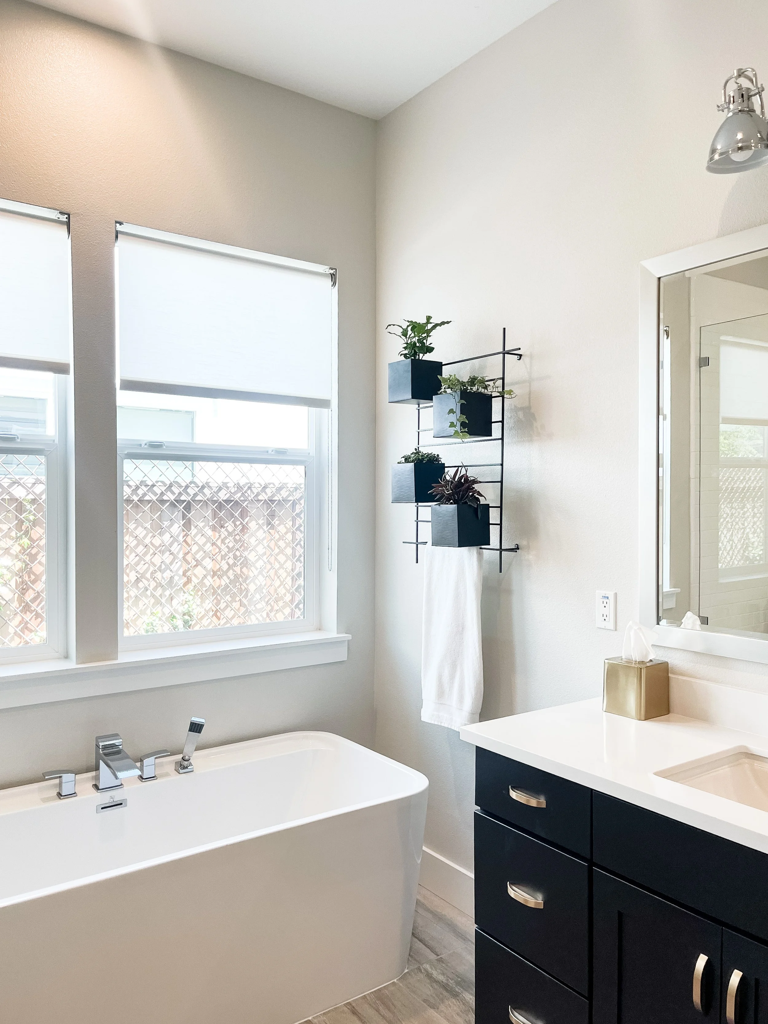 White and black bathroom with soaking tub and brass hardware--Casa Limones interior design