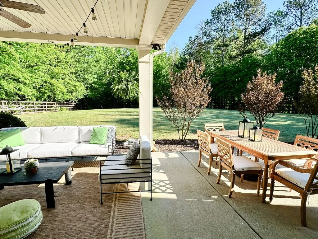 Backyard patio sofa and dining table with natural sisal rug and black coffee table--Casa Limones interior design
