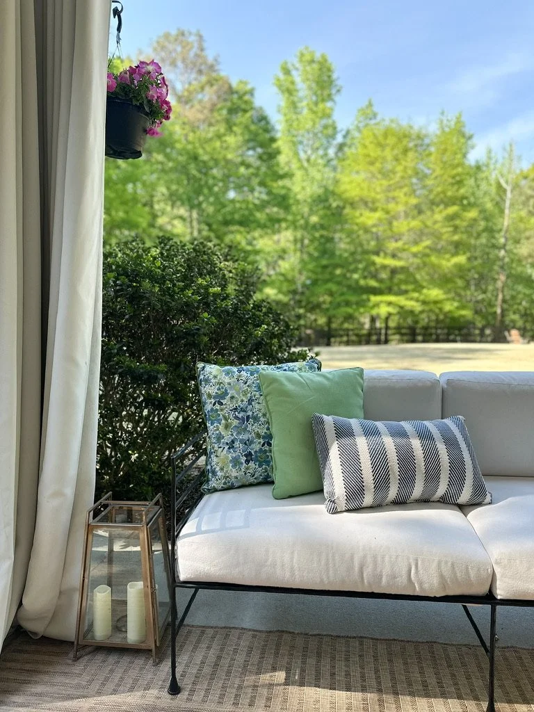 Backyard outdoor sofa with white cushions and blue and green pillows--Casa Limones interior design