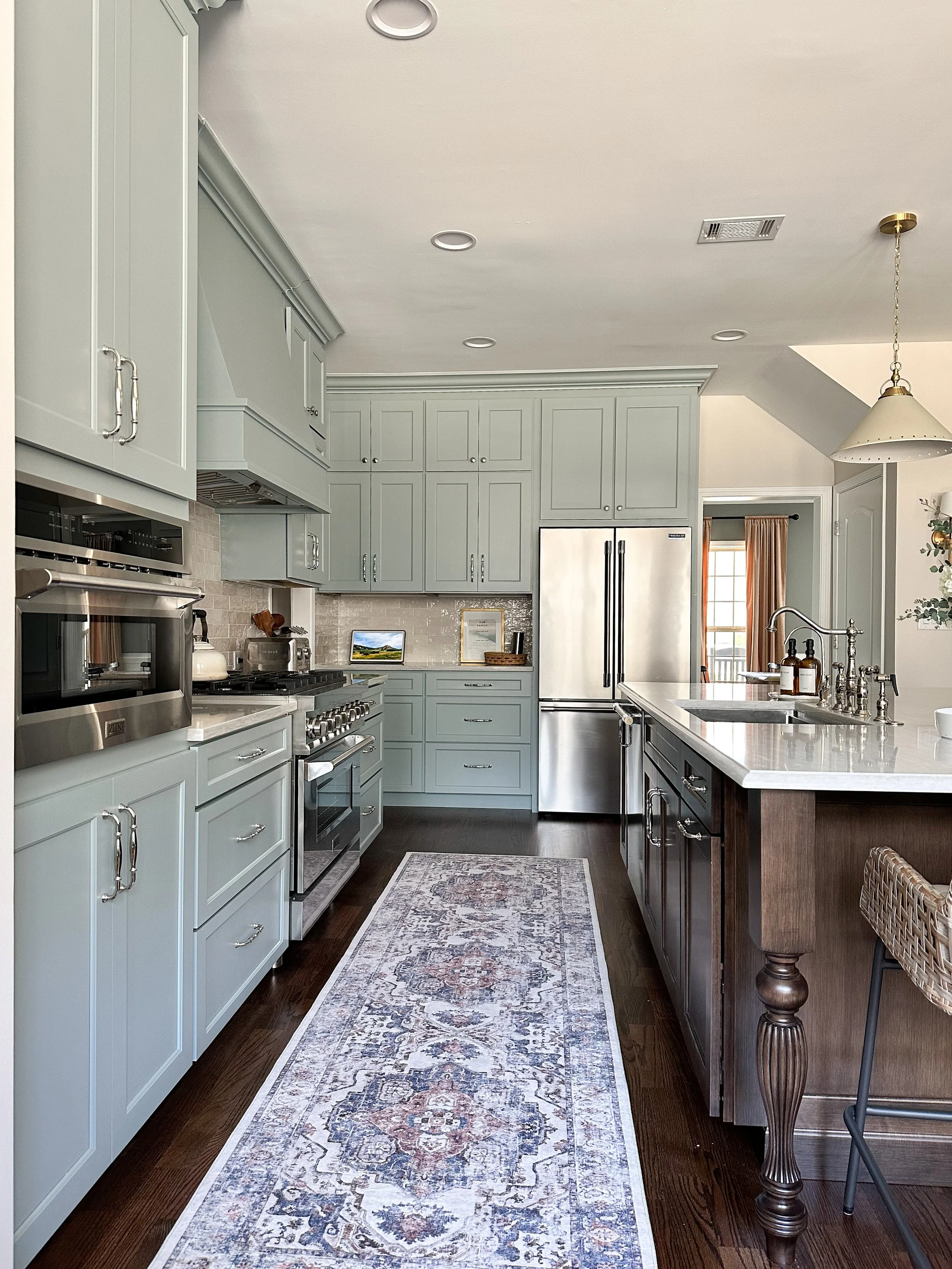 Light blue kitchen with white quartz countertops, walnut island, brass accents, polished nickel hardware, and vintage runner--Casa Limones interior design
