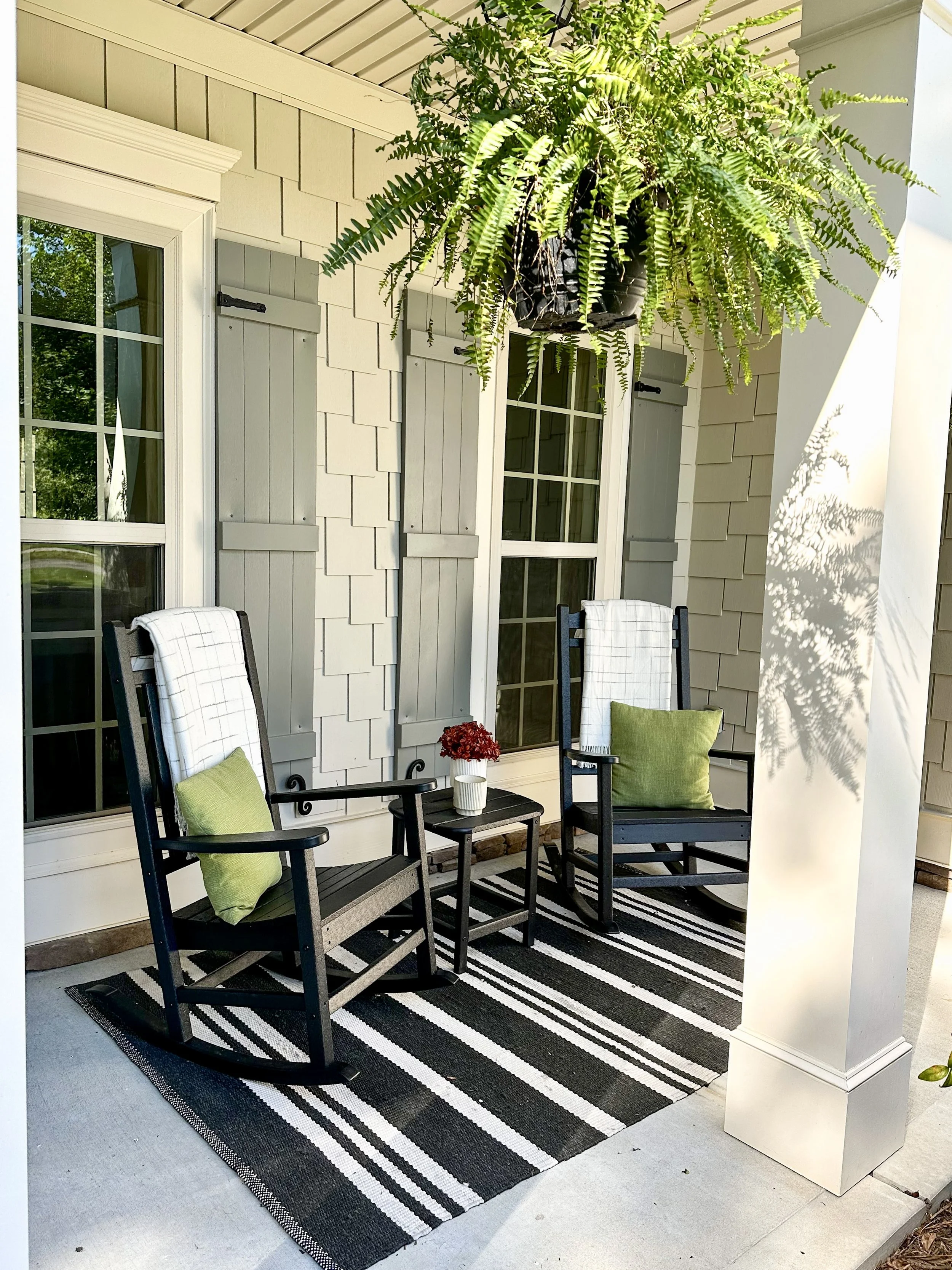 Front porch rocking chairs in black, white, and green color scheme with hanging ferns--Casa Limones interior design