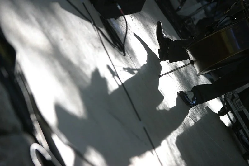 Shadow of a person playing an electric guitar on stage during a performance.
