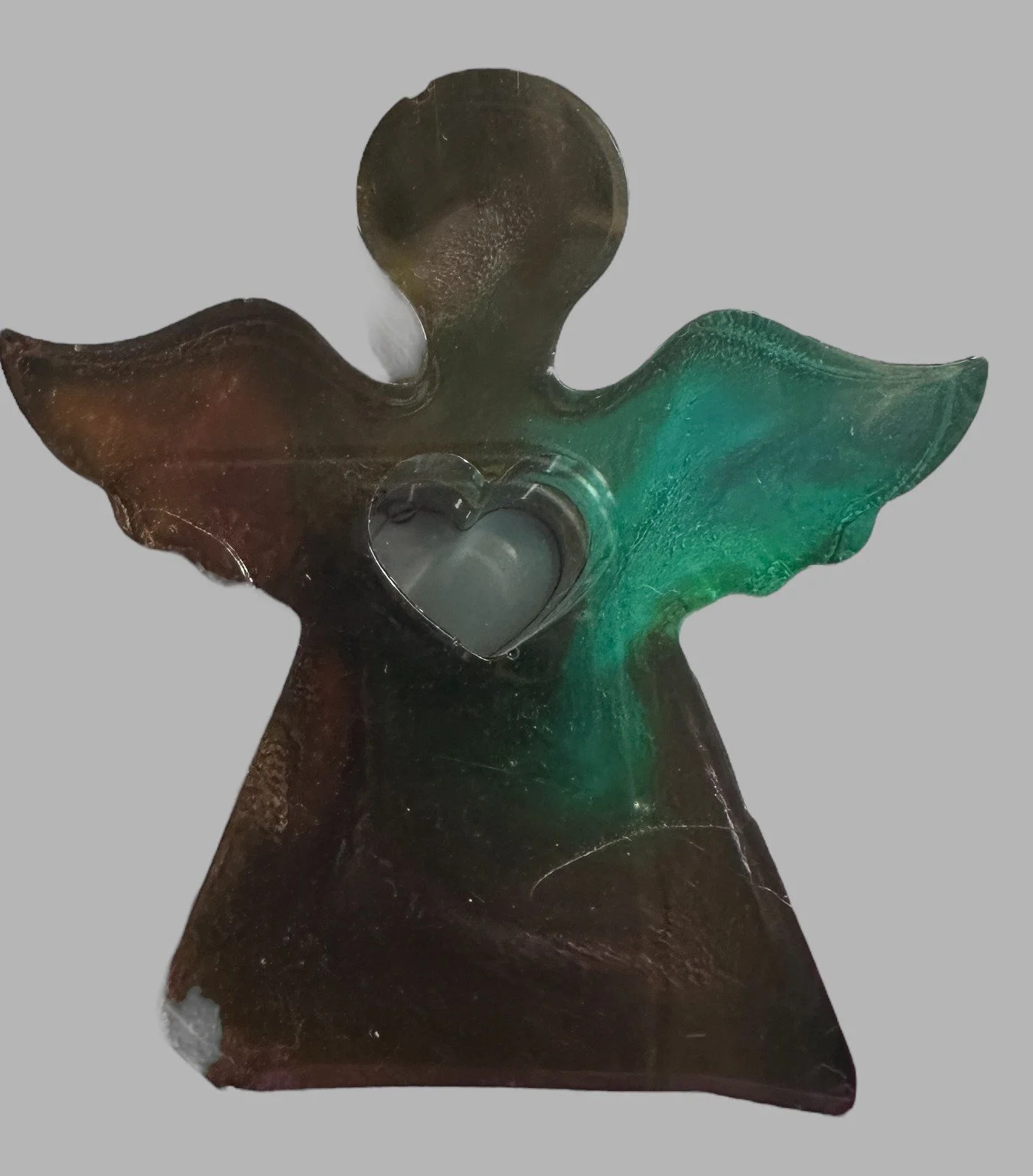 Glass angel figurine with a heart-shaped opening in the chest, featuring green and brown hues.