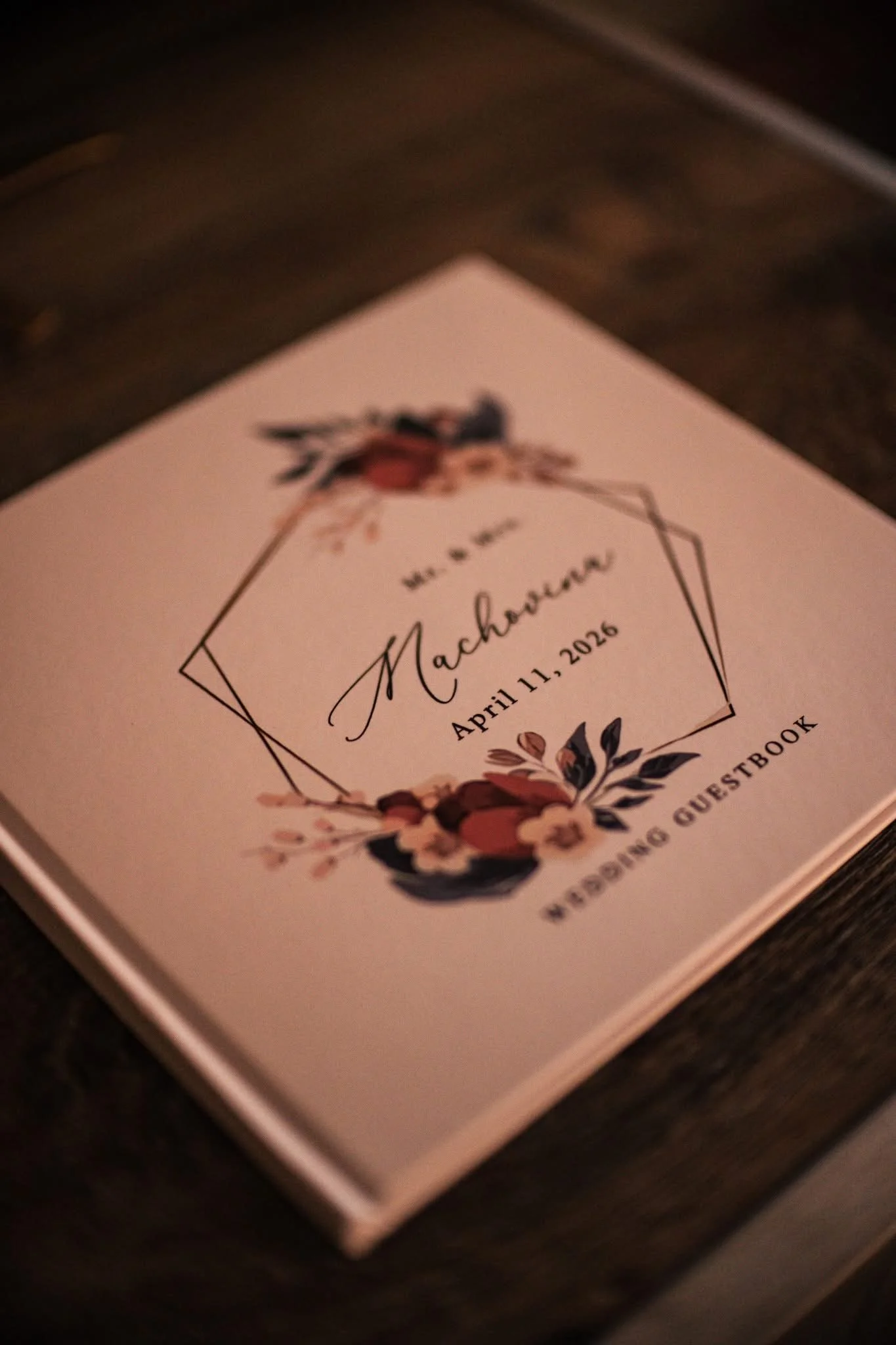 A wedding program or invitation card with floral designs and elegant script, displaying the wedding date April 11, 2026.