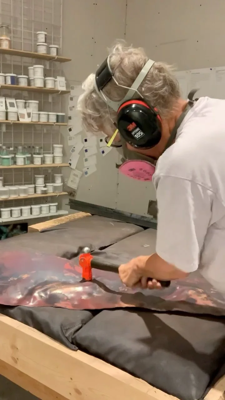Diana Ahrens hand-hammering annealed copper in custom work area.