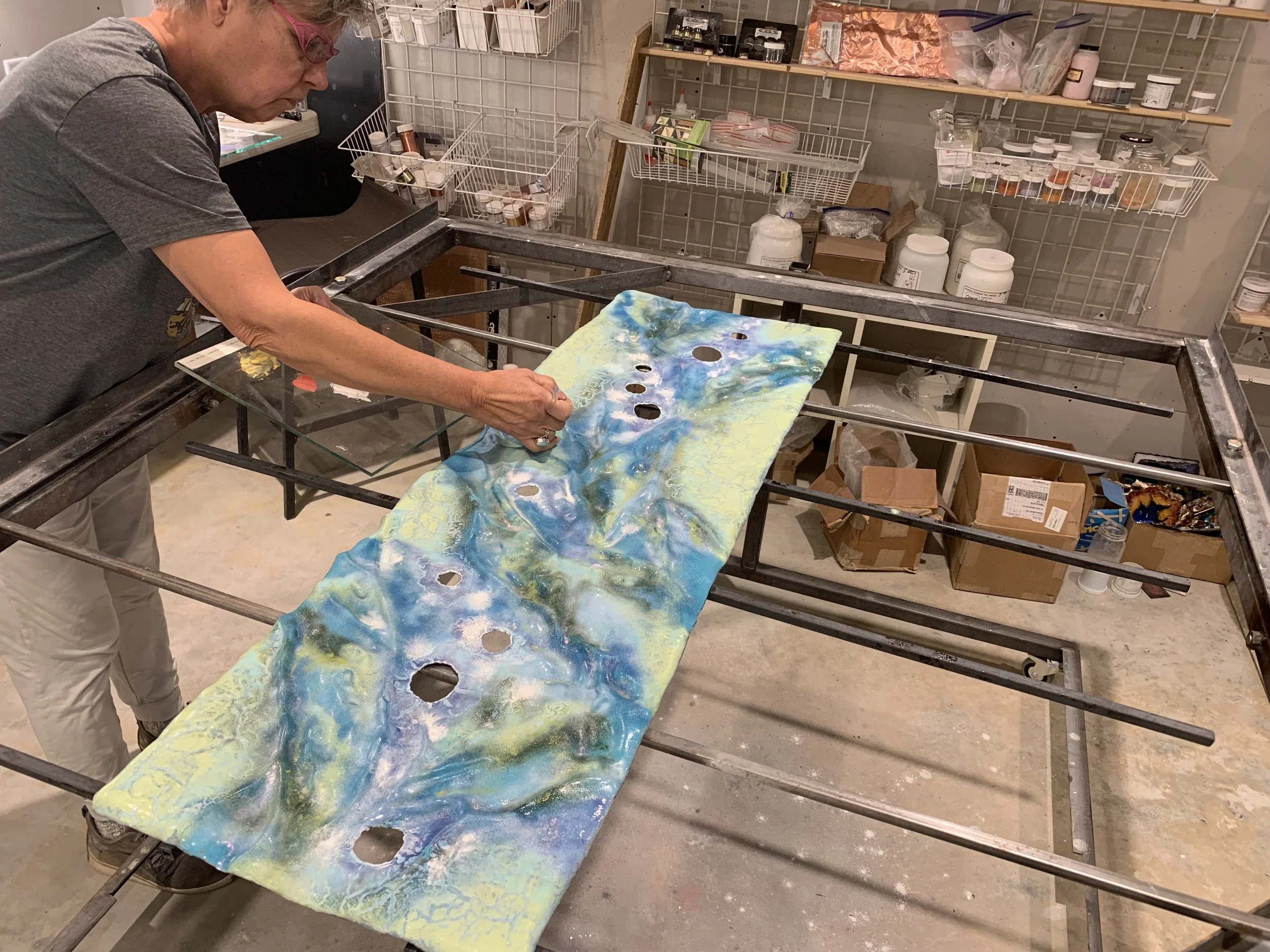 Diana Ahrens working with finely ground vitreous enamel in her glass studio.