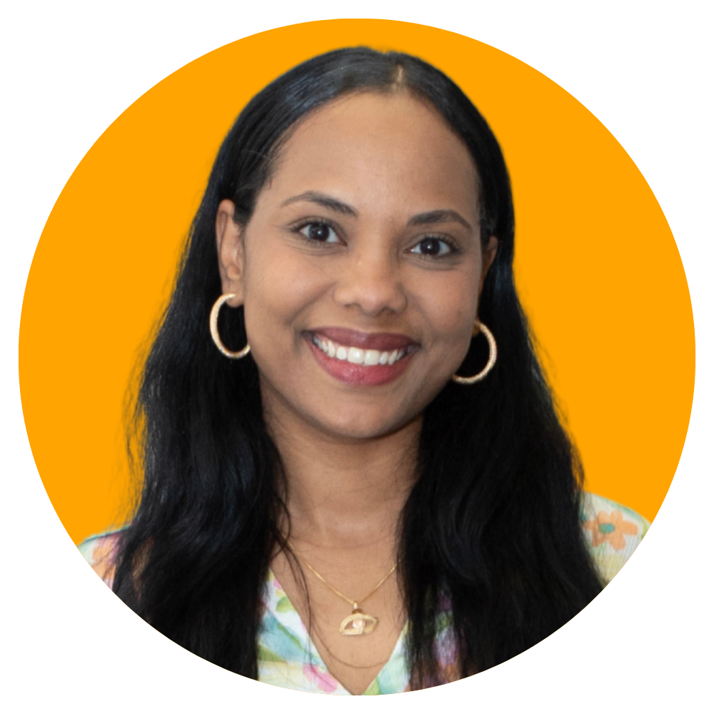 A woman with long black hair, wearing gold hoop earrings, a gold necklace, and a colorful top, smiling against an orange background.