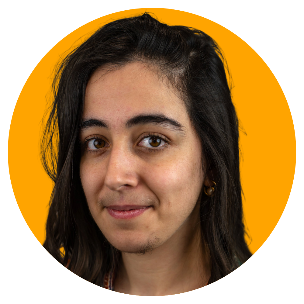 Close-up portrait of a young woman with dark brown hair and brown eyes, smiling slightly, against an orange background.