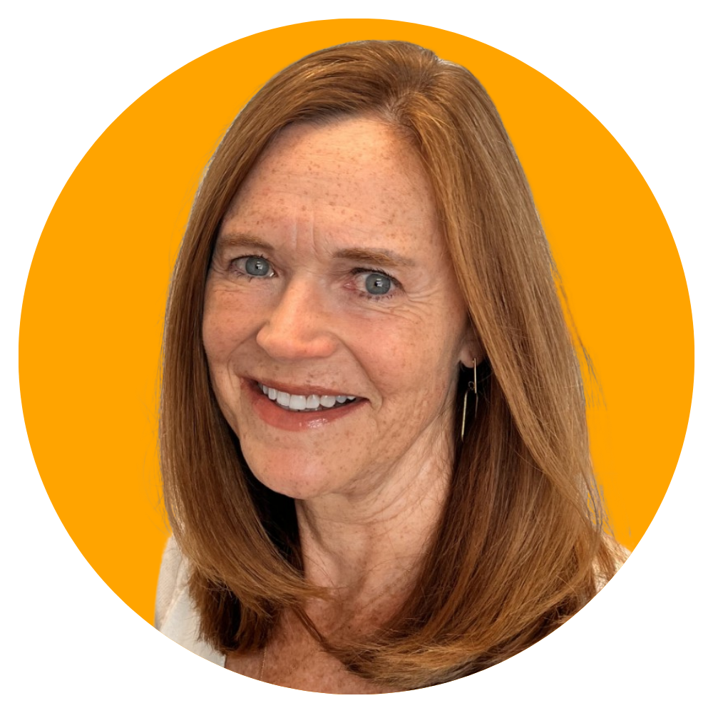 A woman with red hair and fair skin, smiling with teeth showing, wearing a white top and a single earring, against an orange circular background.