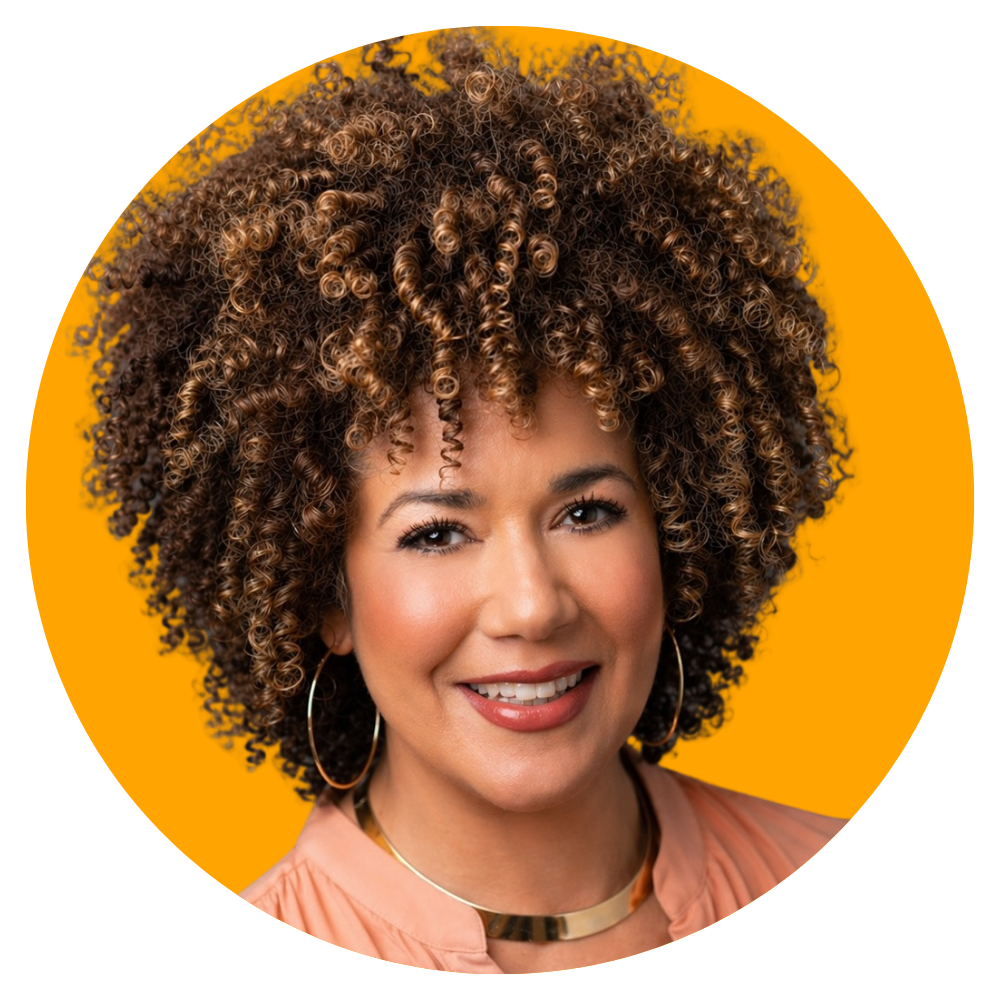 A woman with a big, curly, brown and blonde hairstyle, wearing hoop earrings and a pink top, smiling against a bright yellow background.