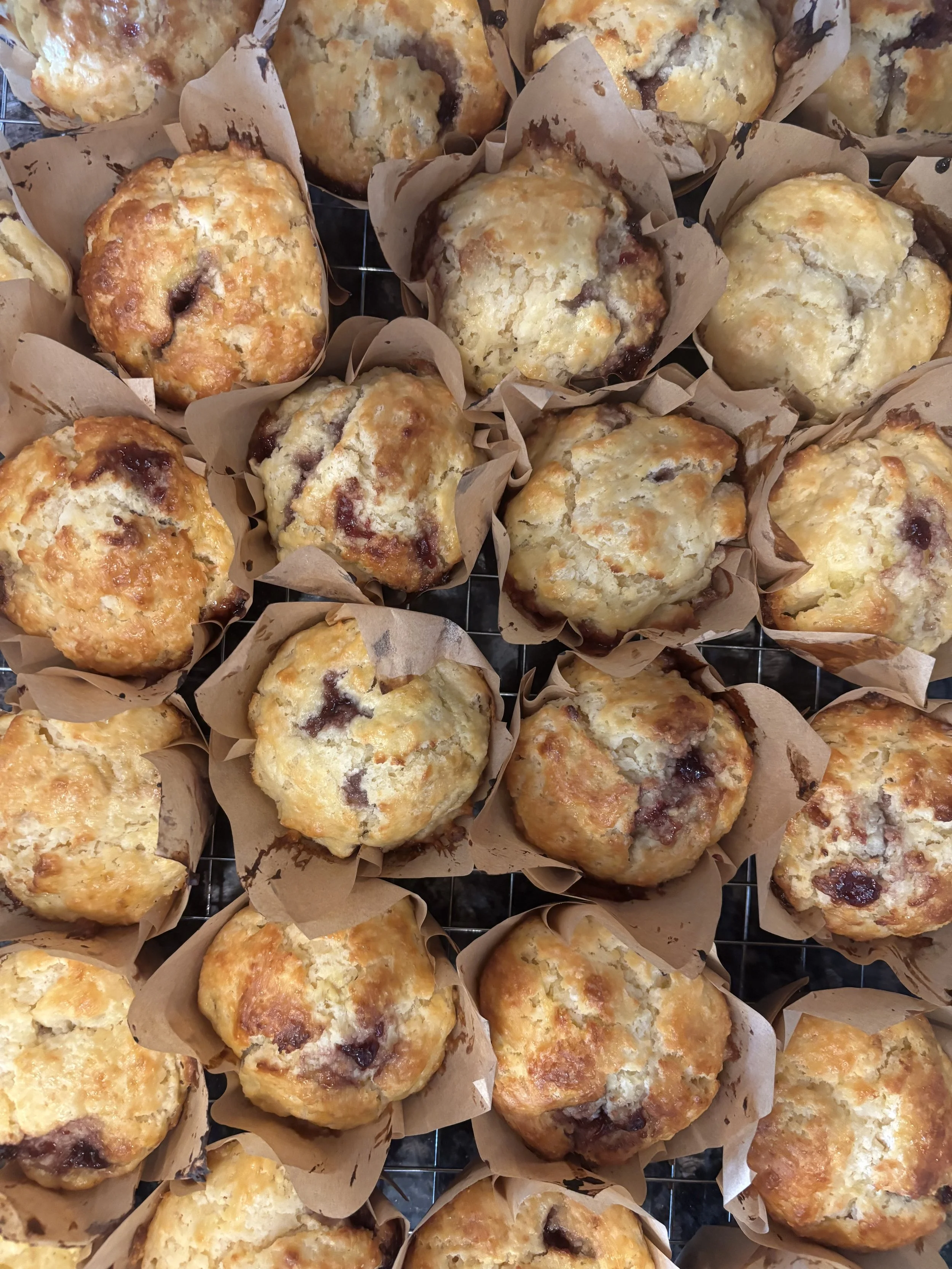 A batch of freshly baked muffins in paper liners on a cooling rack.