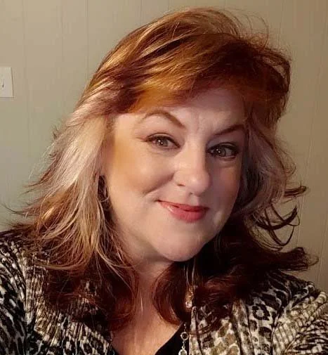 Angie Glover, artist, image of the woman smiling at the camera.