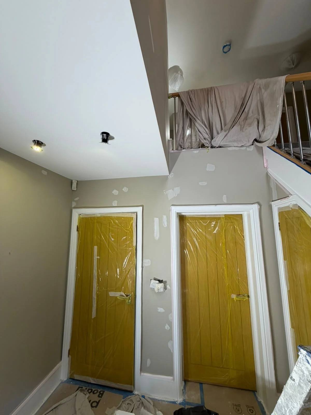  Doors masked in plastic and dust sheets over the banister before painting 