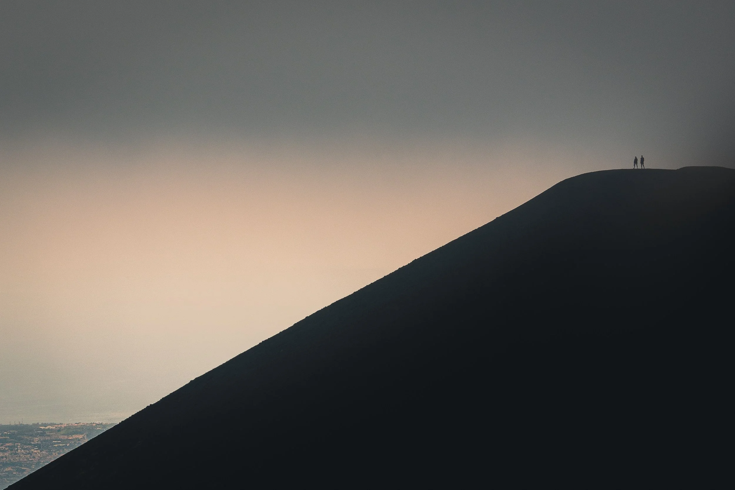 Dark mountain ridge emerging through fog and soft light